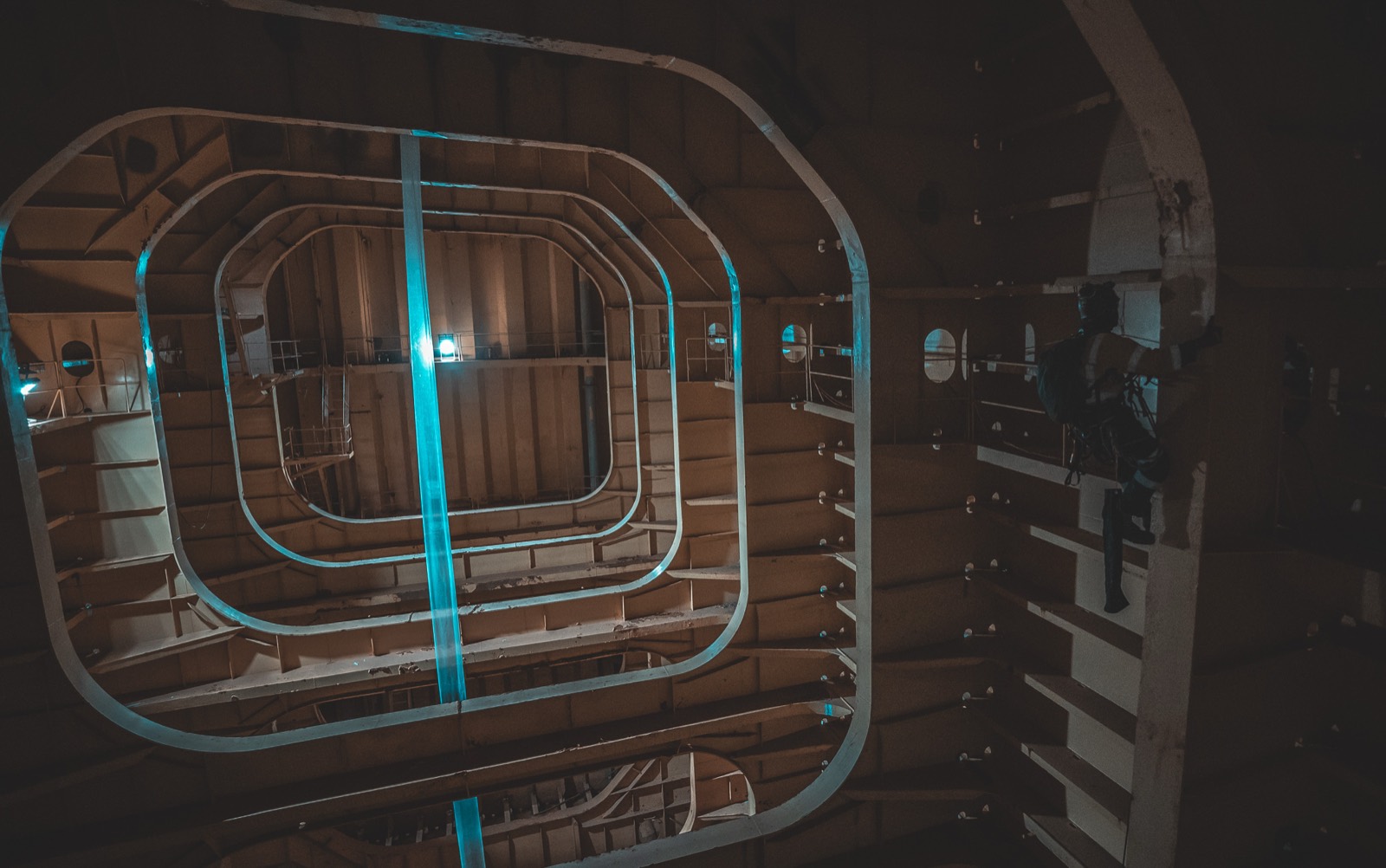 Rope-access technician inside a large illuminated internal structure