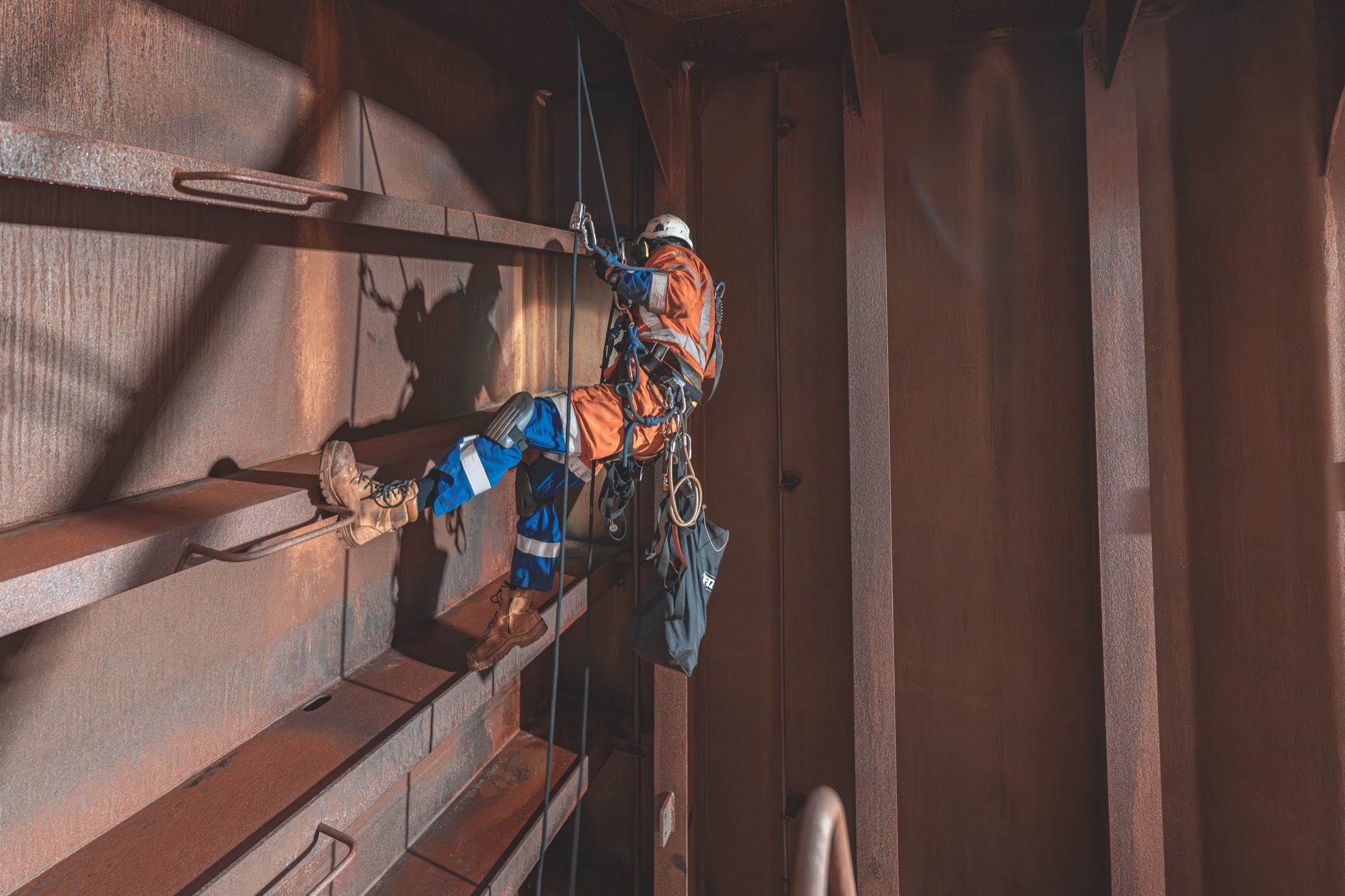 Technician inspecting the internal steel structure of a ship's hull